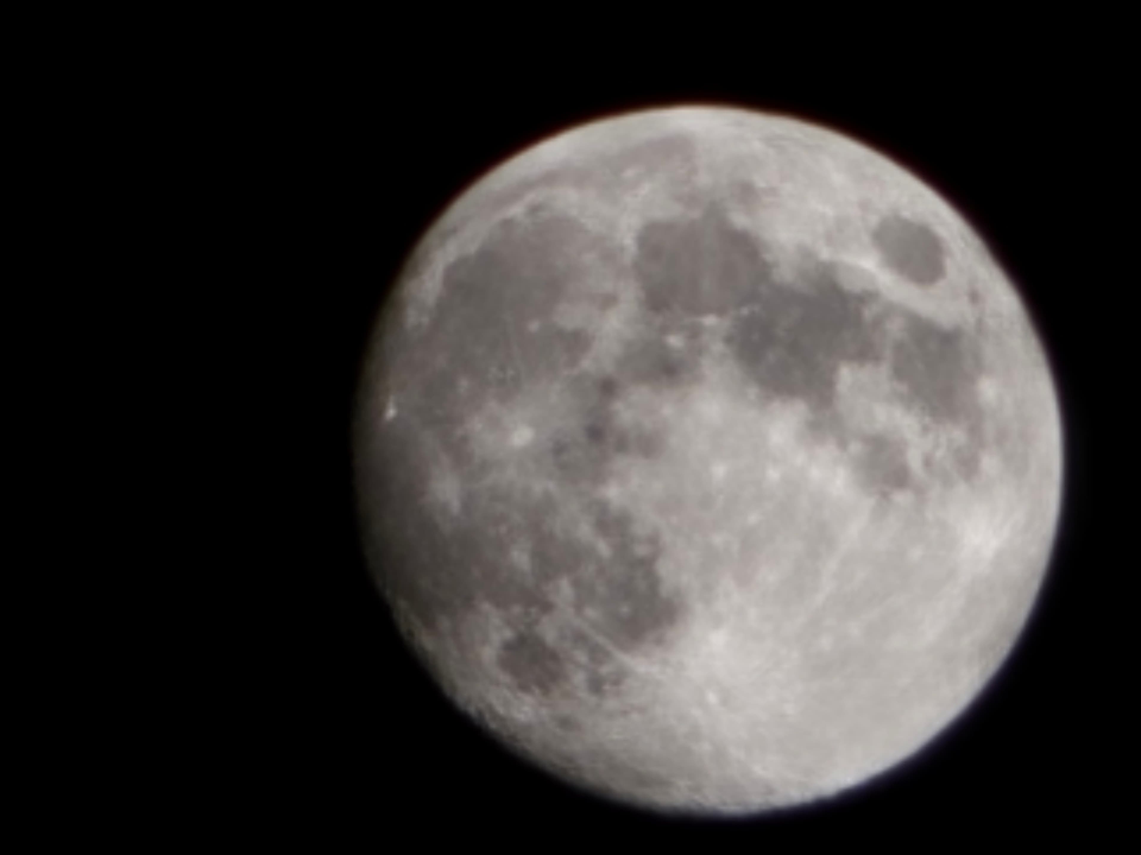 The moon against a black sky, showing gray maria and craters.